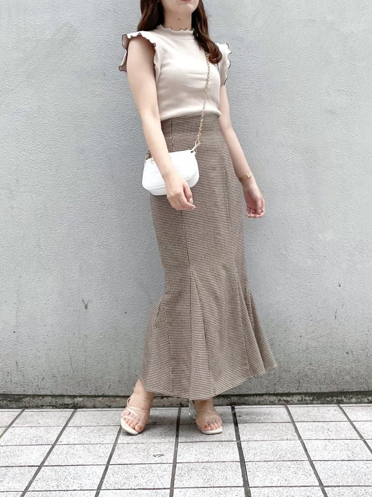 ホワイト系のショルダーバッグ、ブラウン系のスカート、その他のサンダルを着用したレディースの夏コーディネートの3枚目の写真