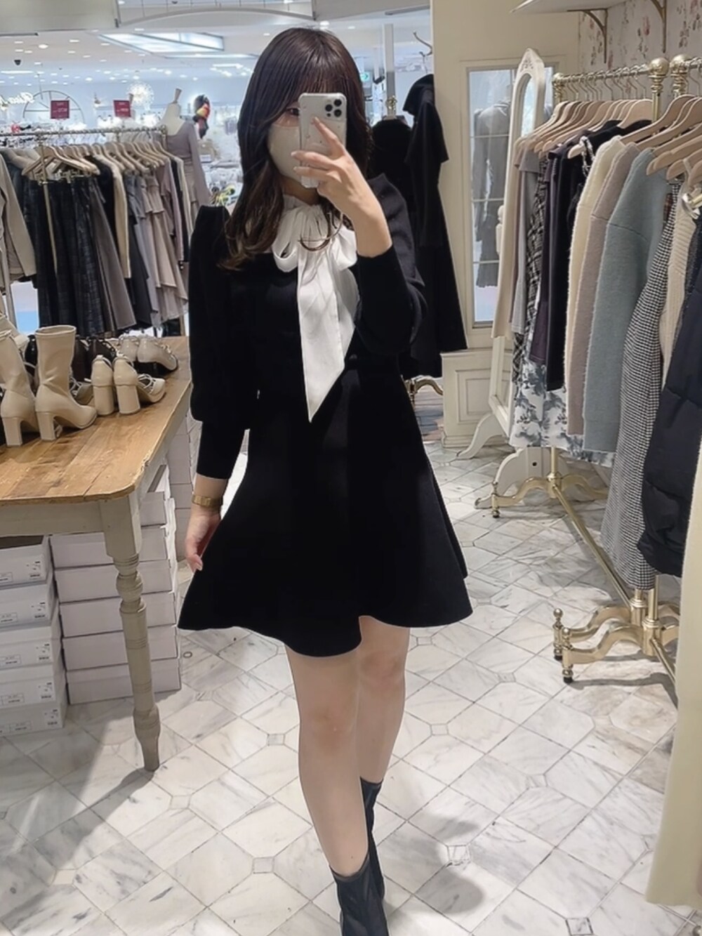 ブラック系のワンピース、ブラック系のブーツを着用したレディースの冬コーディネートの2枚目の写真