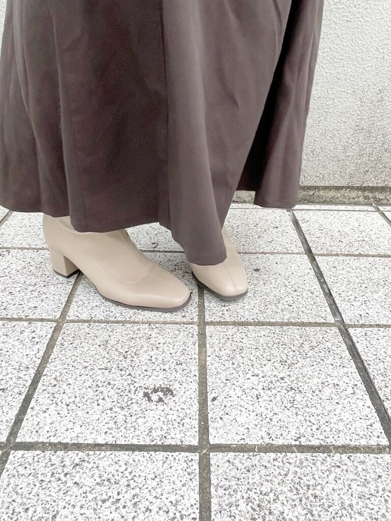 ホワイト系のカーディガン/ボレロ、ブラウン系のスカート、ベージュ系のブーツを着用したレディースの秋コーディネートの5枚目の写真