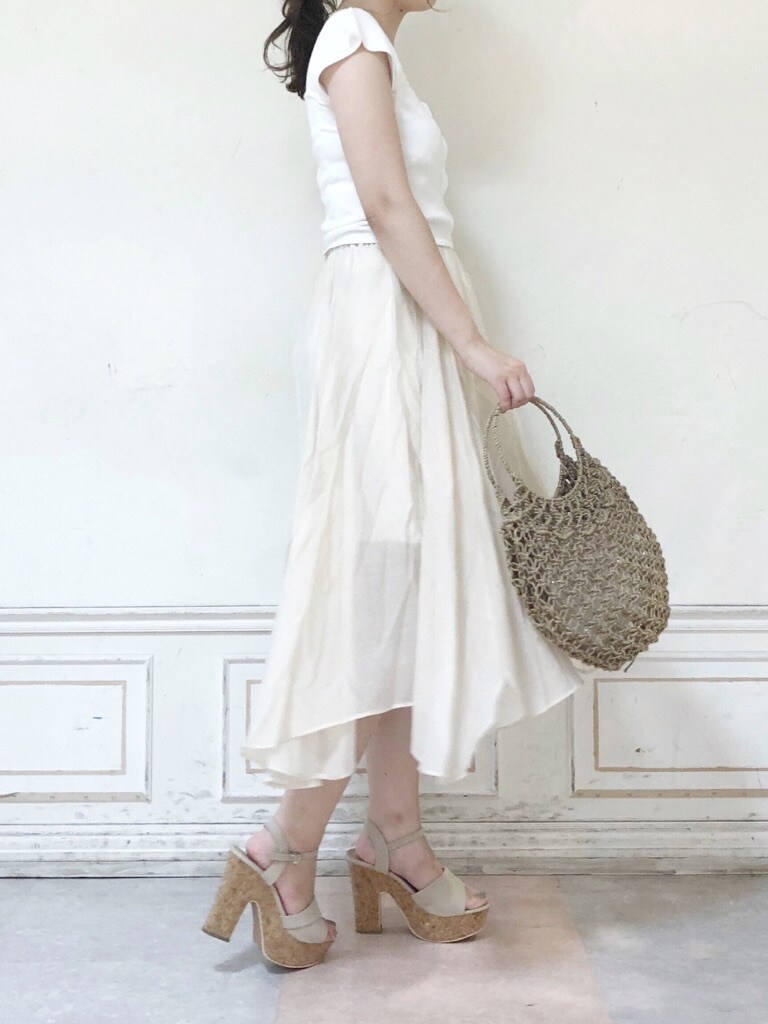 ベージュ系のハンドバッグ、ホワイト系のスカート、ベージュ系のサンダルを着用したレディースの夏コーディネートの3枚目の写真