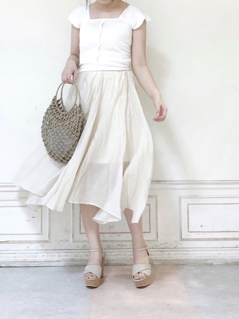 ベージュ系のハンドバッグ、ホワイト系のスカート、ベージュ系のサンダルを着用したレディースの夏コーディネートの4枚目の写真