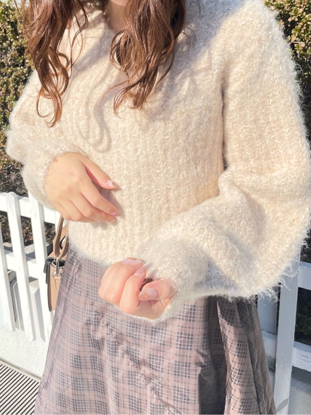 ブラウン系のスカート、ブラウン系のニット/セーター、ベージュ系のブーツを着用したレディースの冬コーディネートの5枚目の写真