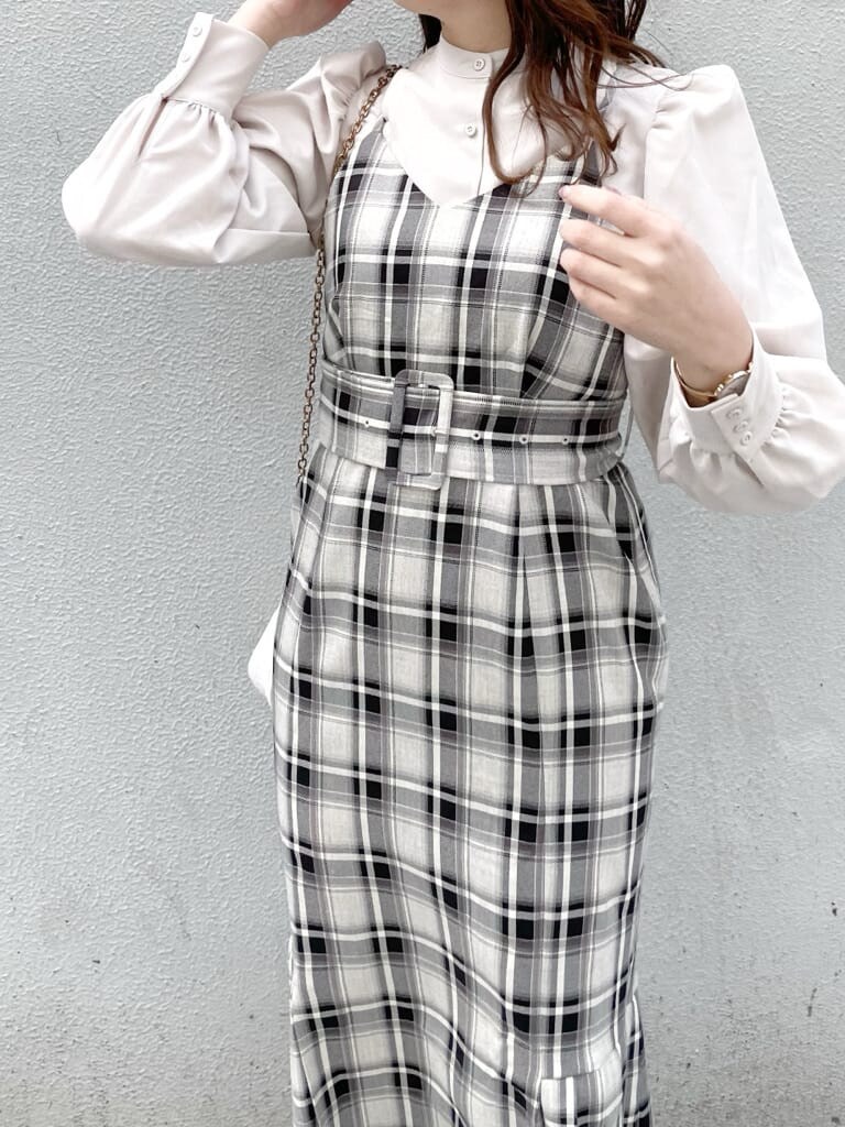 グレー系のジャンパースカート、ホワイト系のパンプス、ベージュ系のシャツ/ブラウスを着用したレディースの冬コーディネートの3枚目の写真