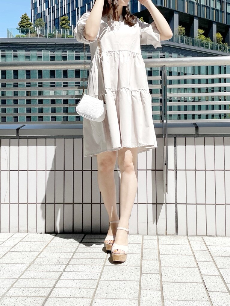 ベージュ系のサンダル、ホワイト系のショルダーバッグ、ベージュ系のチュニックを着用したレディースの春コーディネートの4枚目の写真