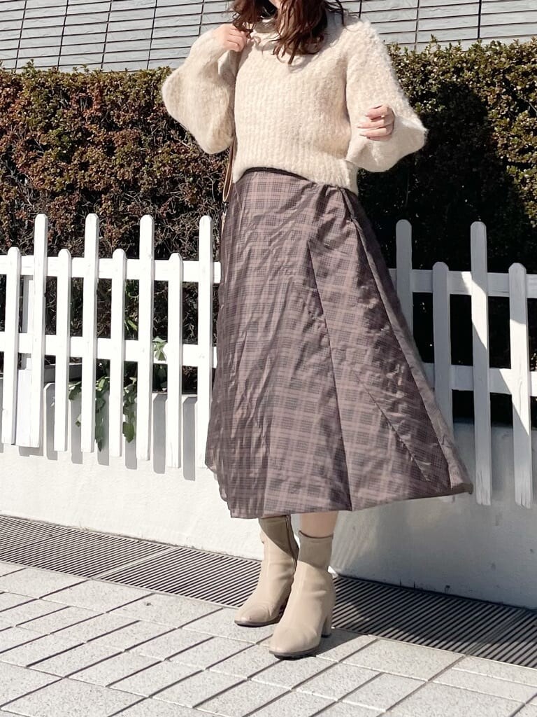 ブラウン系のスカート、ブラウン系のニット/セーター、ベージュ系のブーツを着用したレディースの冬コーディネートの3枚目の写真