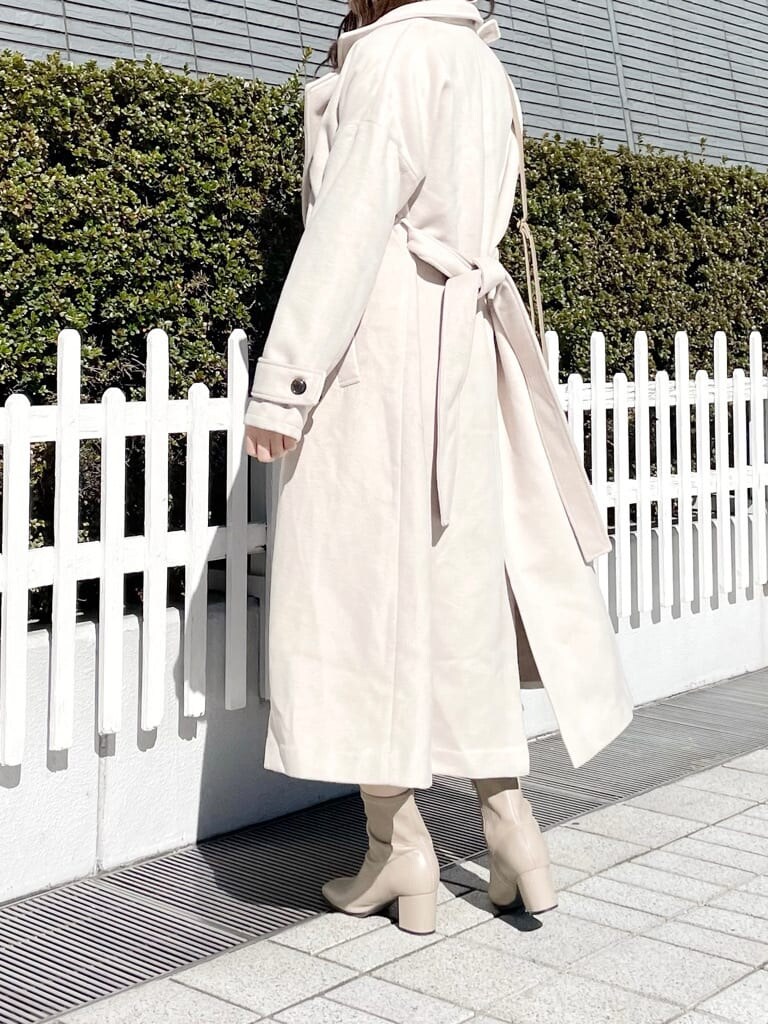 ホワイト系のその他アウター、ベージュ系のハンドバッグ、ベージュ系のブーツを着用したレディースの秋コーディネートの2枚目の写真