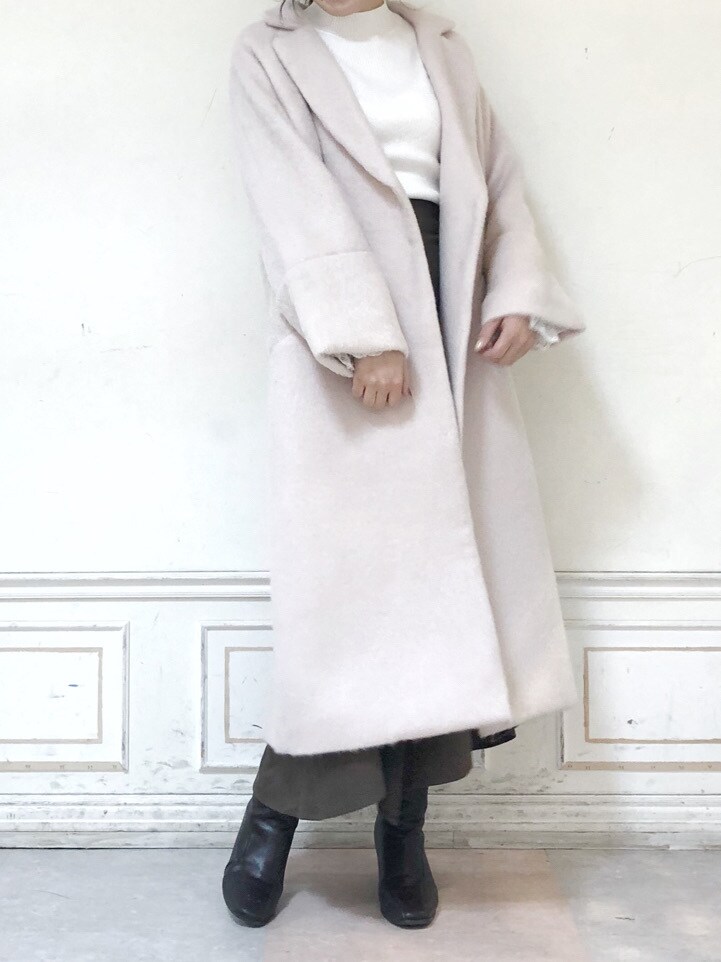 ブラウン系のブーツ、ブラウン系のスカート、ホワイト系のニット/セーターを着用したレディースの秋コーディネートの3枚目の写真