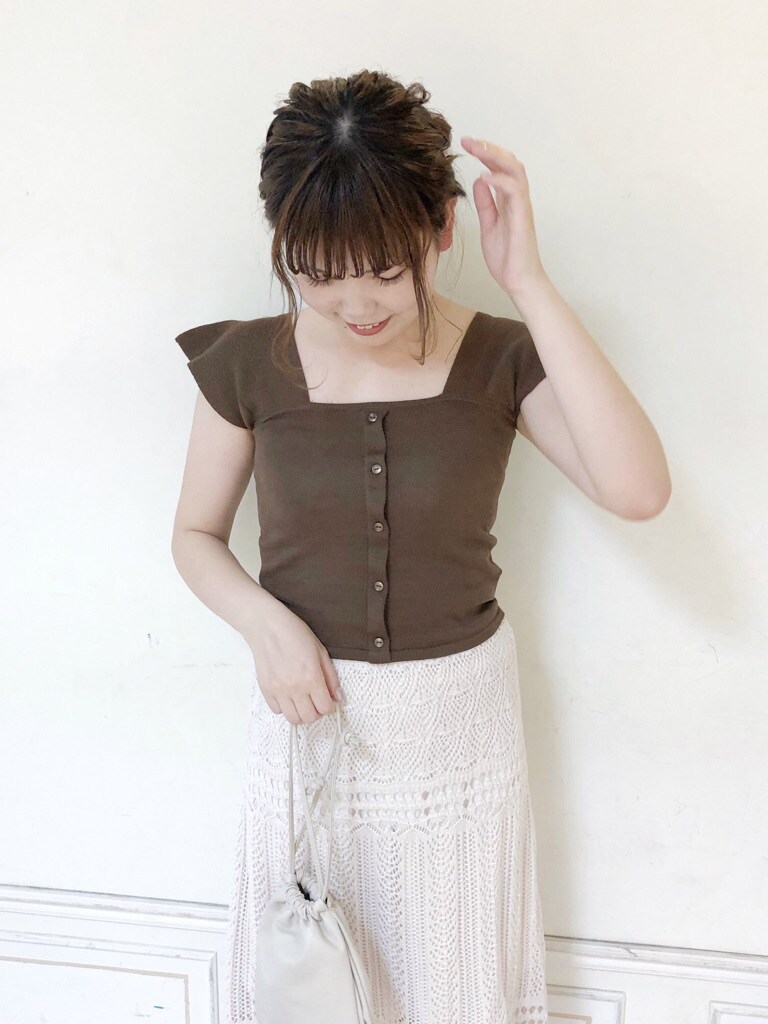 ホワイト系のスカート、ホワイト系のハンドバッグ、ブラウン系のサンダルを着用したレディースの夏コーディネートの4枚目の写真