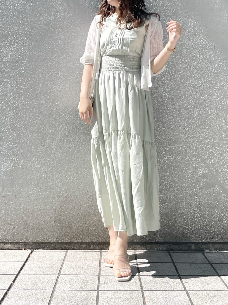 パープル系のサンダル、ホワイト系のショルダーバッグ、グリーン系のワンピースを着用したレディースの春コーディネートの3枚目の写真