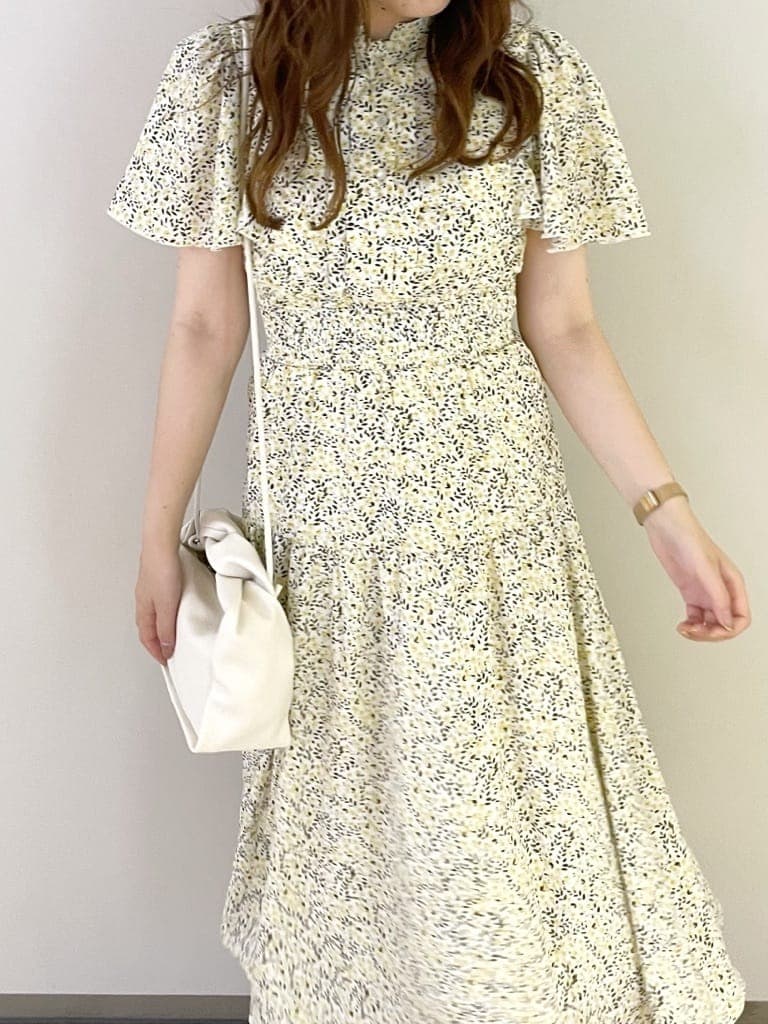 ホワイト系のハンドバッグ、イエロー系のワンピース、その他のサンダルを着用したレディースの夏コーディネートの4枚目の写真