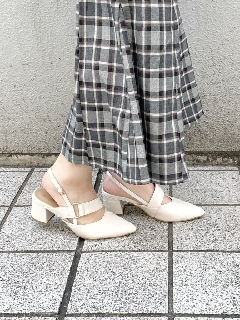 ベージュ系のトレンチコート、ブラック系のスカート、グリーン系のニット/セーターを着用したレディースの冬コーディネートの8枚目の写真