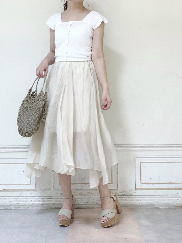 ベージュ系のハンドバッグ、ホワイト系のスカート、ベージュ系のサンダルを着用したレディースの夏コーディネートの2枚目の写真