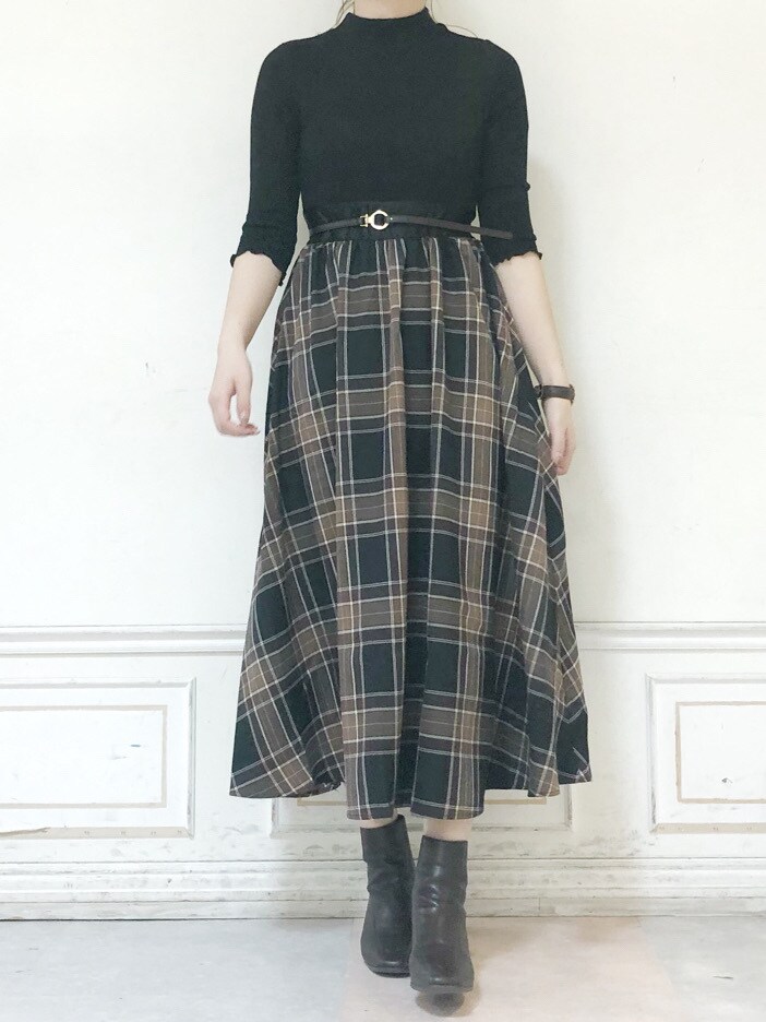 ブラウン系のブーツ、グリーン系のチェスターコート、ブラック系のワンピースを着用したレディースの秋コーディネートの5枚目の写真