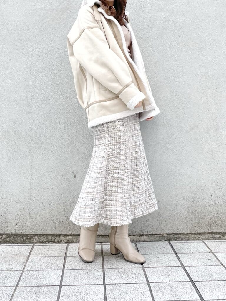 ホワイト系のブルゾン、ベージュ系のブーツ、ベージュ系のニット/セーターを着用したレディースの冬コーディネートの2枚目の写真