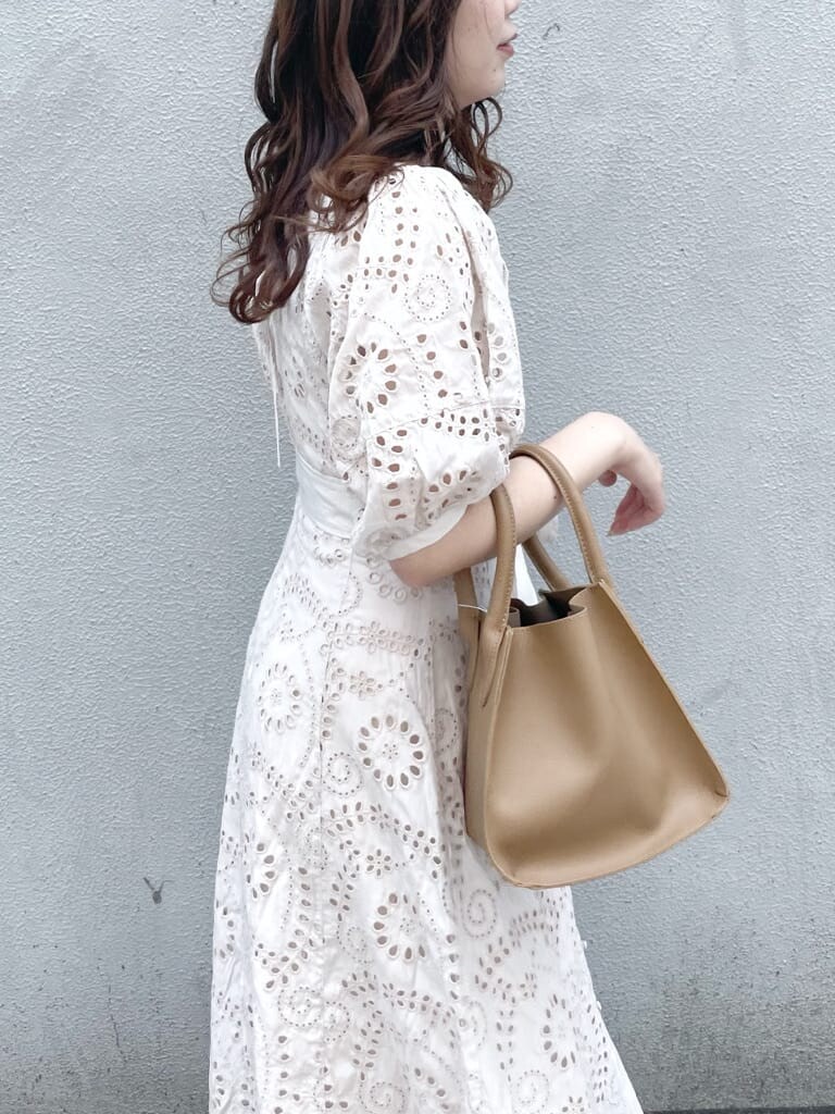 ホワイト系のワンピース、ベージュ系のハンドバッグ、ホワイト系のパンプスを着用したレディースの春コーディネートの5枚目の写真