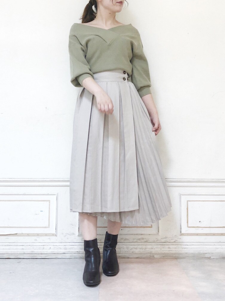 ベージュ系のスカート、ブラウン系のブーツ、グリーン系のニット/セーターを着用したレディースの秋コーディネートの2枚目の写真