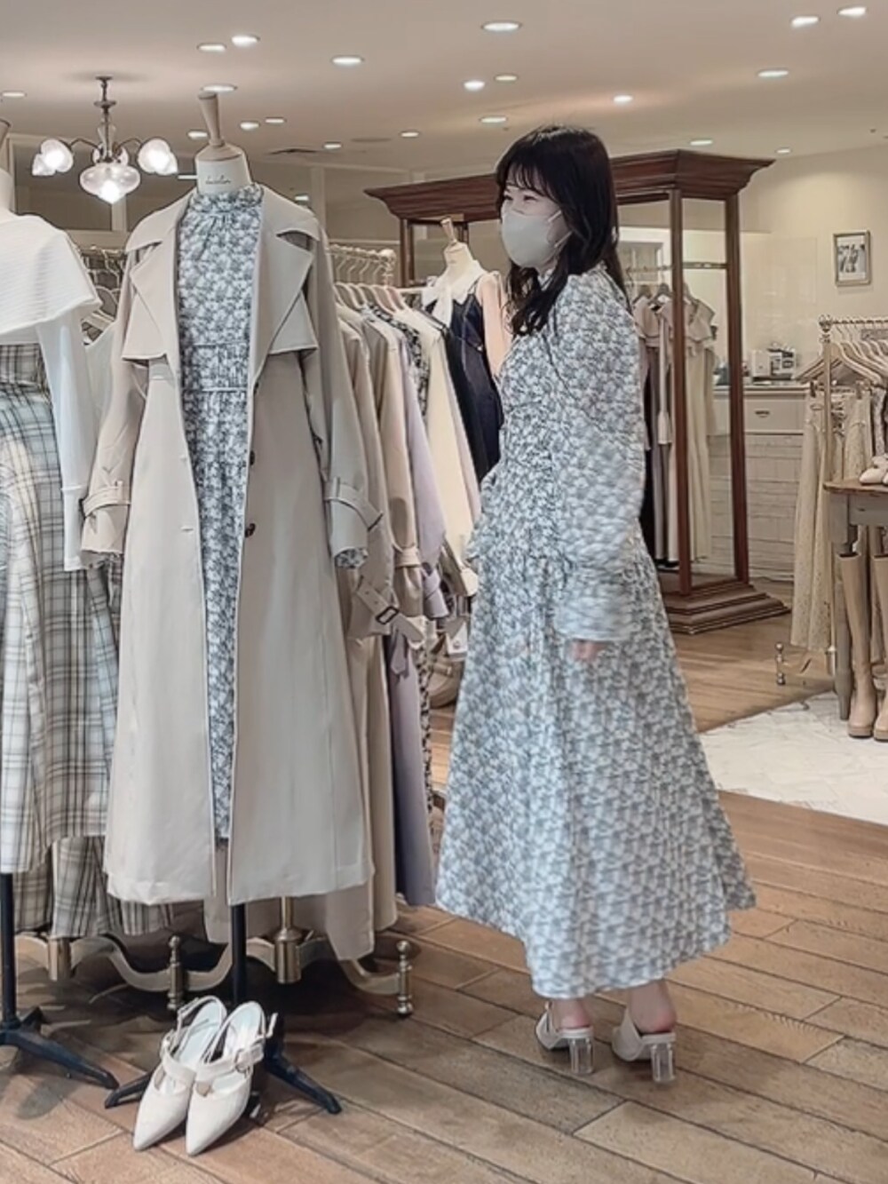 ベージュ系のトレンチコート、ホワイト系のワンピース、ホワイト系のパンプスを着用したレディースの冬コーディネートの4枚目の写真