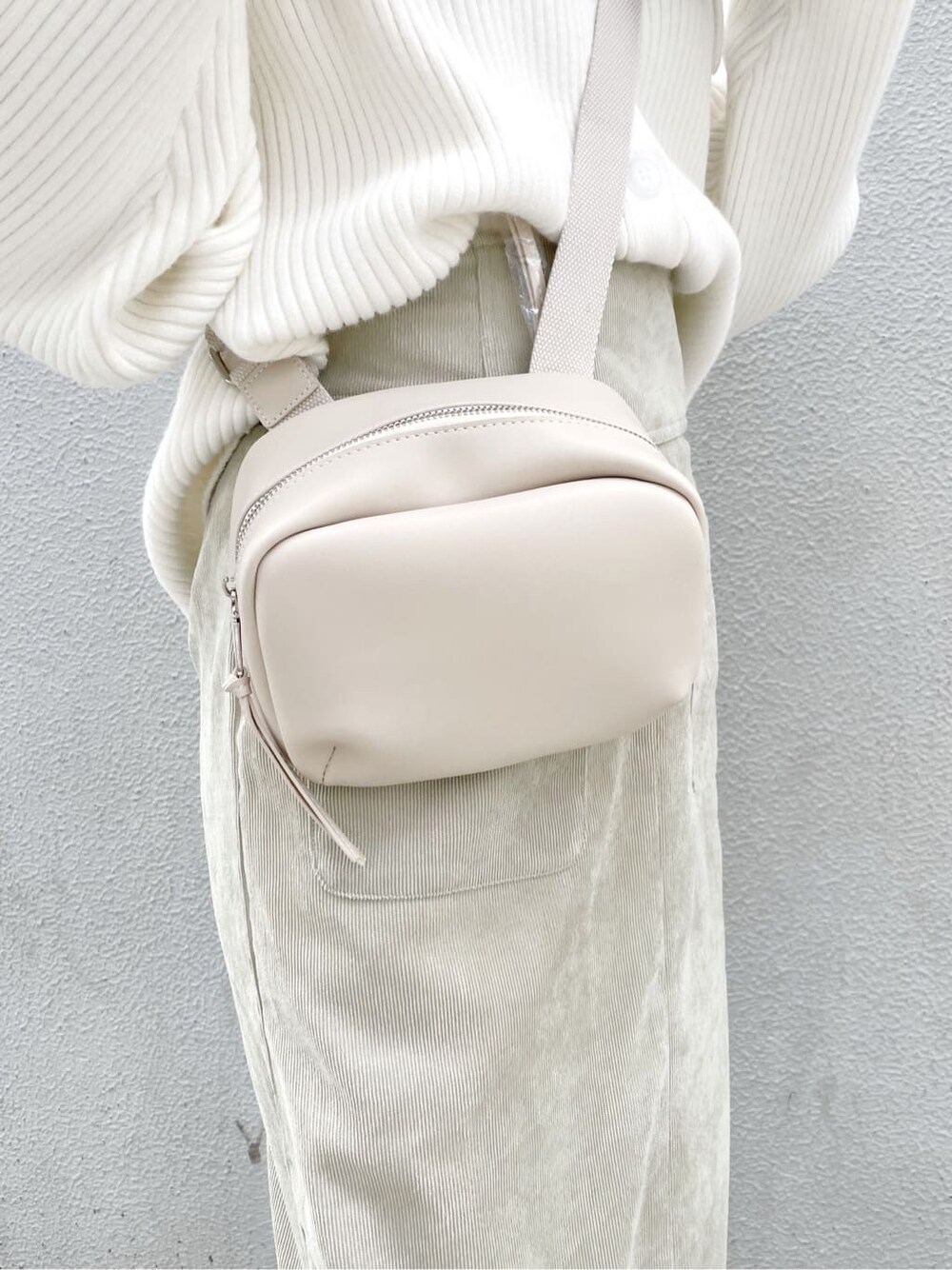 ホワイト系のスニーカー、グリーン系のスカート、ホワイト系のハンドバッグを着用したレディースの秋コーディネートの7枚目の写真