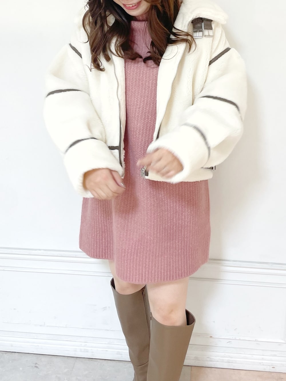 ピンク系のワンピース、ホワイト系のブルゾン、ベージュ系のブーツを着用したレディースの秋コーディネートの3枚目の写真