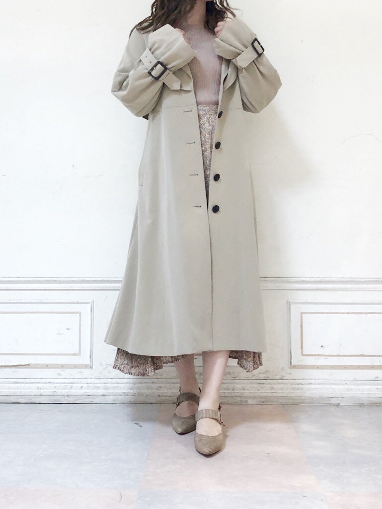 ホワイト系のスカート、ベージュ系のパンプス、ベージュ系のトレンチコートを着用したレディースの夏コーディネートの2枚目の写真