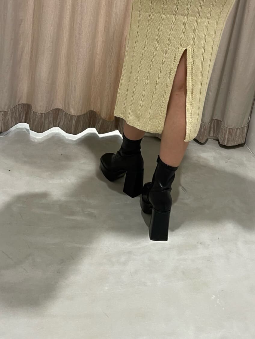 ブラック系のブーツ、ホワイト系のワンピース、ブラウン系のハンドバッグを着用したレディースの秋コーディネートの8枚目の写真