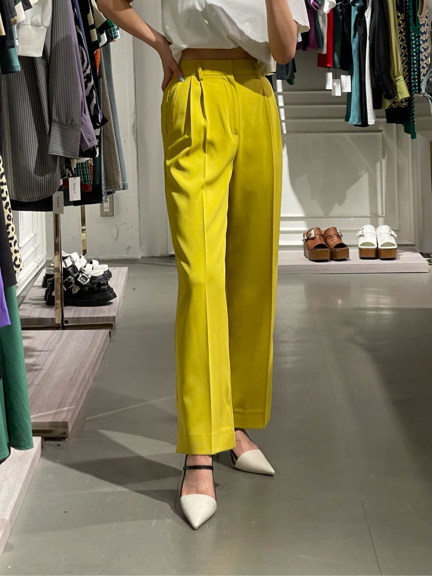 イエロー系のスラックス、ホワイト系のTシャツ/カットソー、ホワイト系のサンダルを着用したレディースの春コーディネートの3枚目の写真