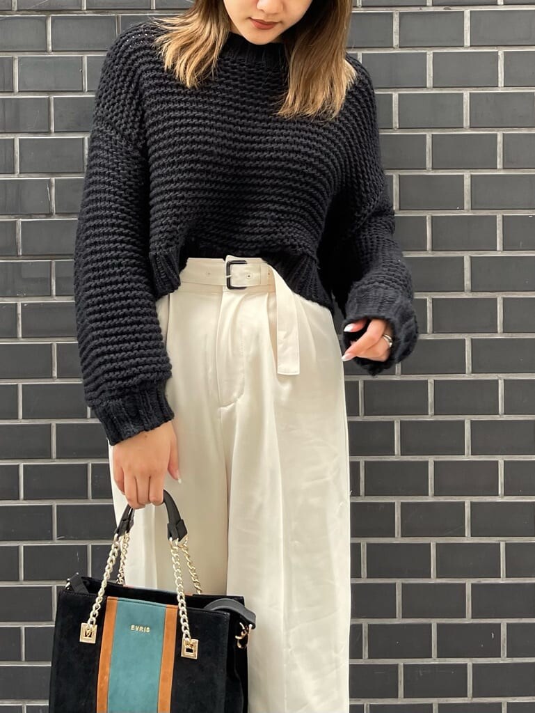 ブラック系のブーツ、ブラック系のニット/セーター、ブラック系のショルダーバッグを着用したレディースの冬コーディネートの4枚目の写真