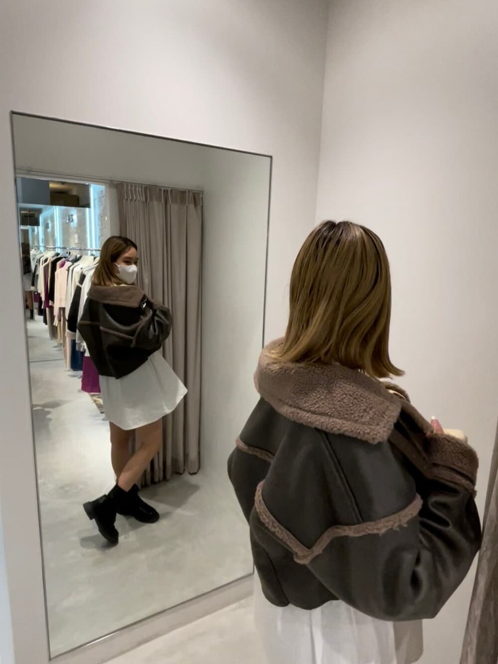 ブラック系のブーツ、グリーン系のブルゾン、ホワイト系のワンピースを着用したレディースの秋コーディネートの2枚目の写真