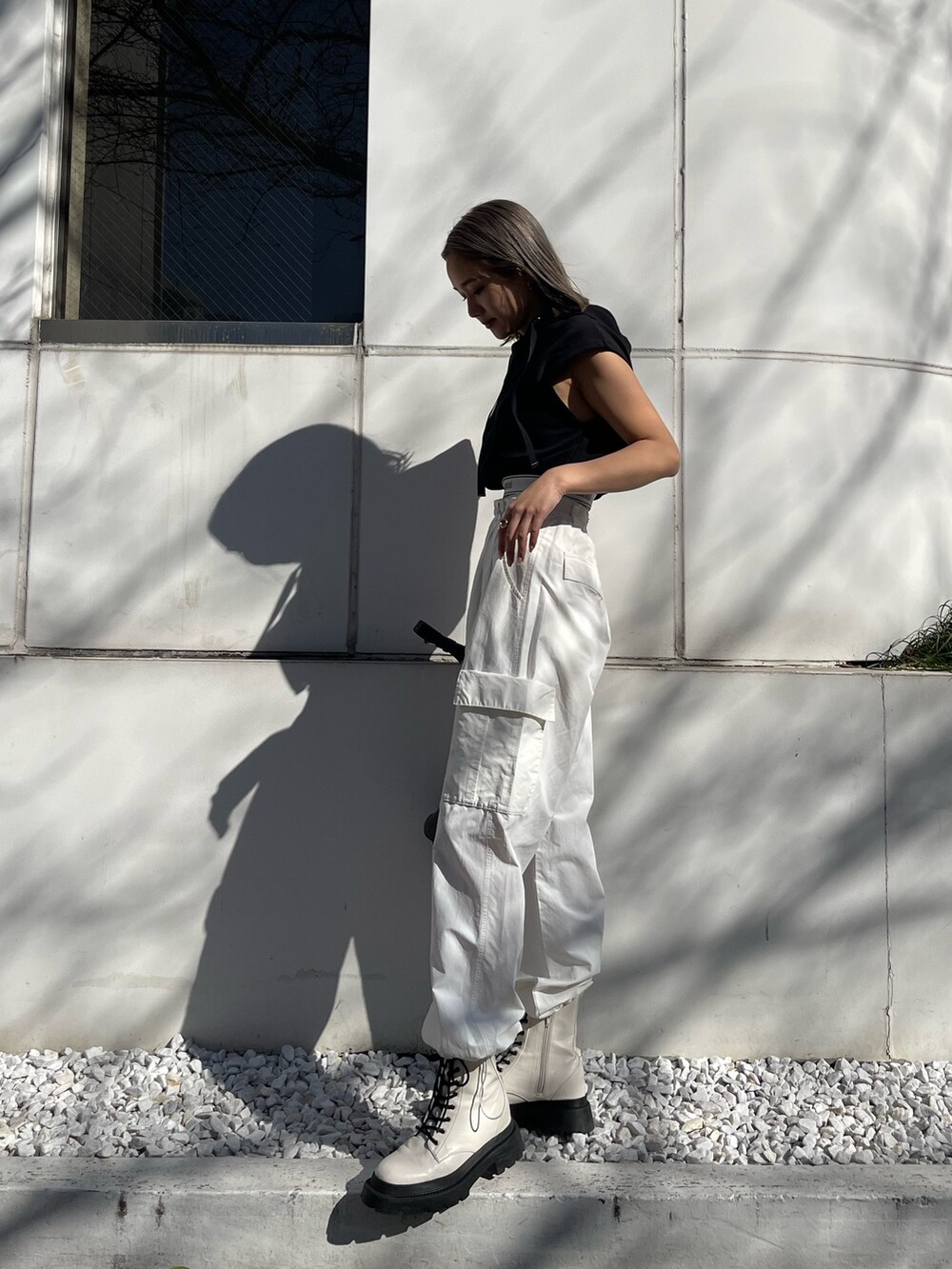 ホワイト系のカーゴパンツ、ブラック系のスウェット、ホワイト系のブーツを着用したレディースの春コーディネートの3枚目の写真