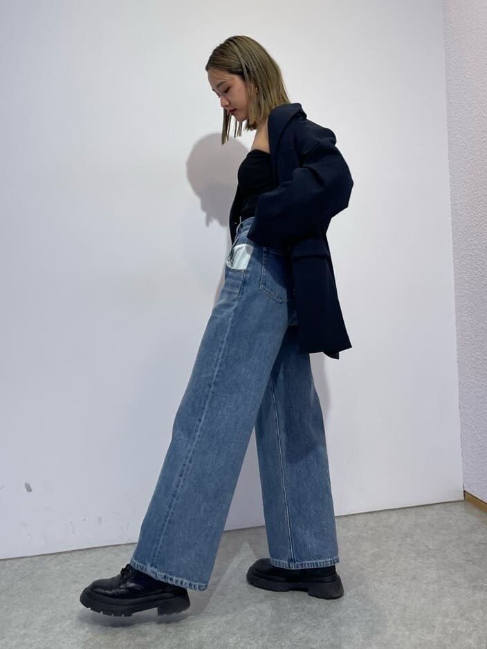 ブラック系のブーツ、ブルー系のデニムパンツ、ブルー系のテーラードジャケットを着用したレディースの秋コーディネートの3枚目の写真