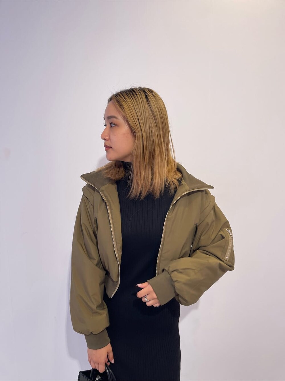 ブラック系のワンピース、ベージュ系のMA-1、ブラック系のショルダーバッグを着用したレディースの秋コーディネートの4枚目の写真