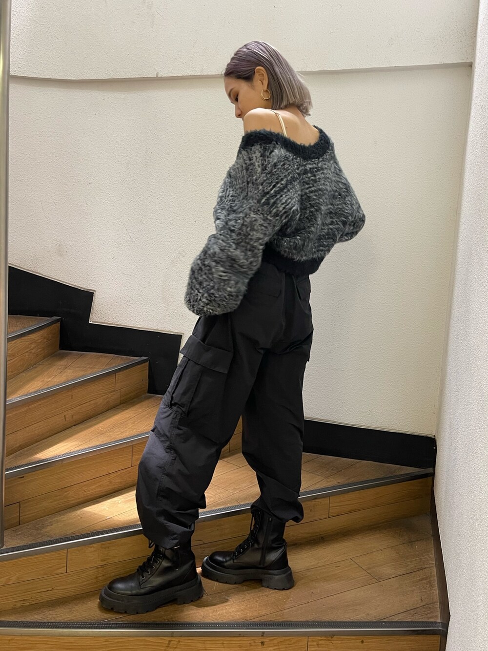 ブラック系のカーゴパンツ、ブラック系のブーツ、ブラック系のカーディガン/ボレロを着用したレディースの秋コーディネートの2枚目の写真