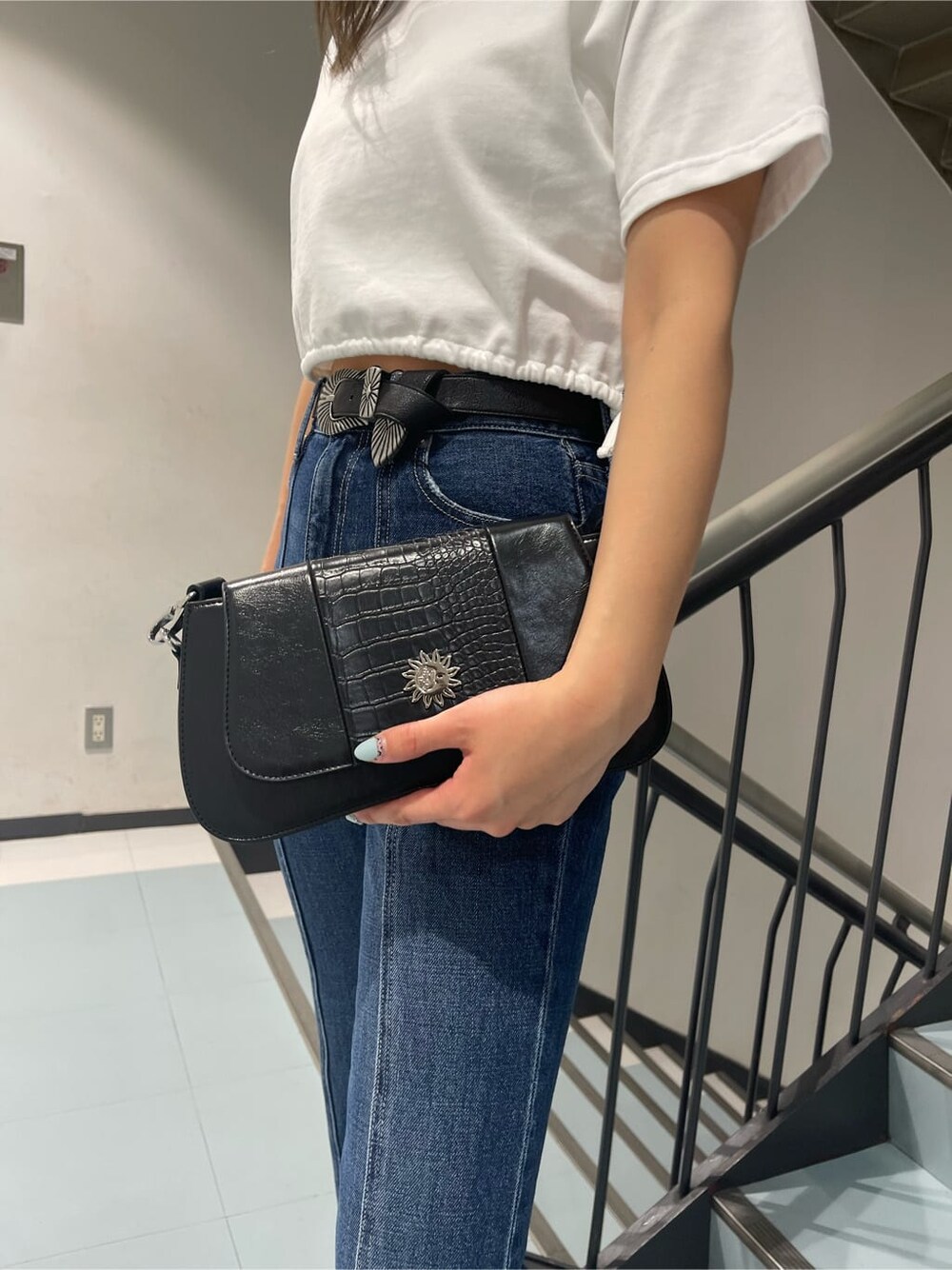 ホワイト系のTシャツ/カットソー、ブラック系のブーツ、ブルー系のデニムパンツを着用したレディースの春コーディネートの5枚目の写真