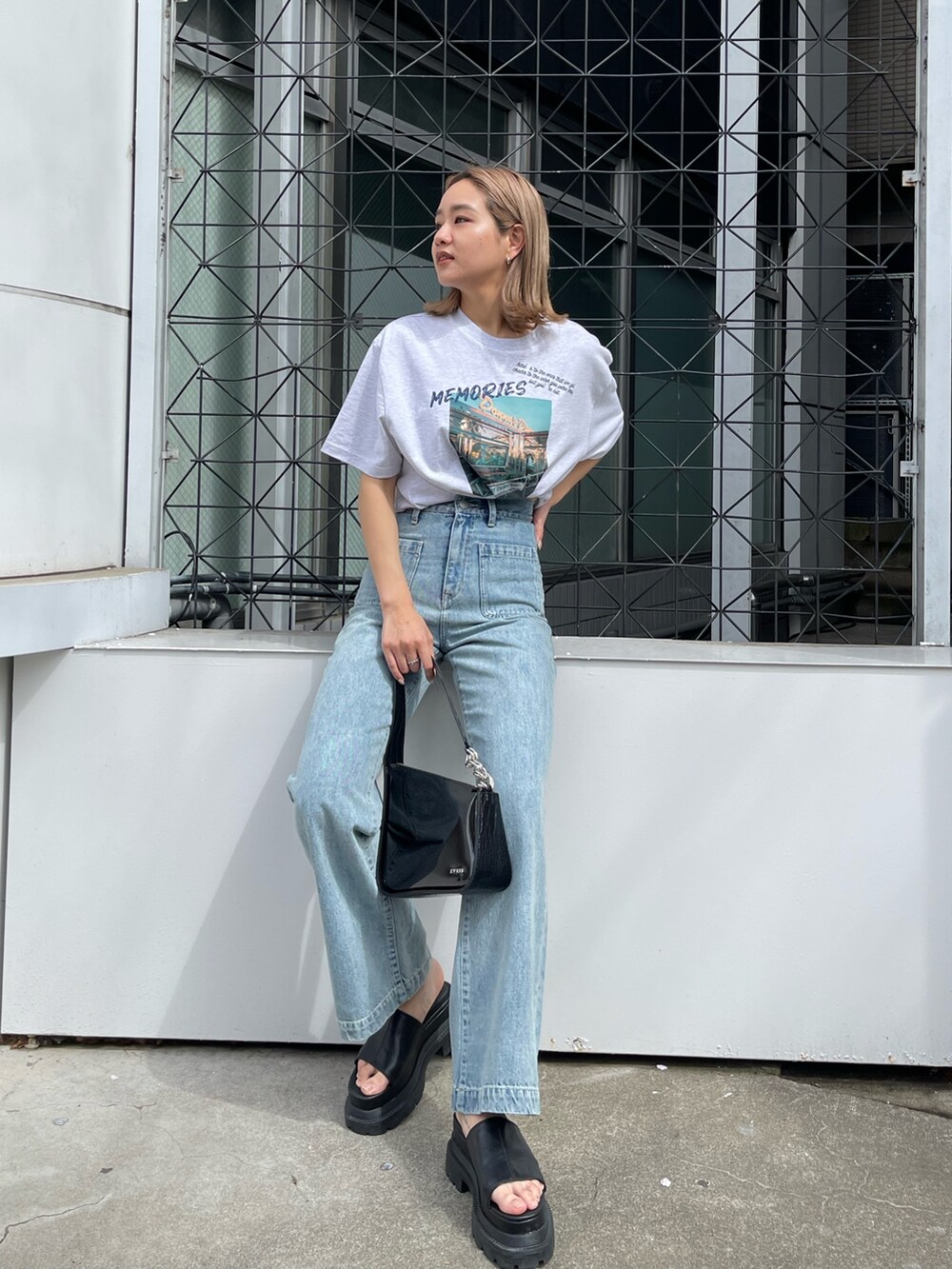 グレー系のTシャツ/カットソー、ブルー系のデニムパンツ、ブラック系のサンダルを着用したレディースの春コーディネートの2枚目の写真