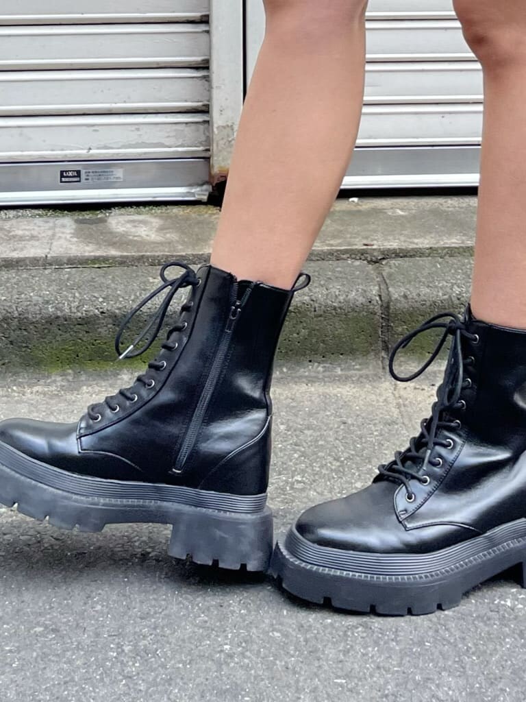 ブラック系のスカート、ブラック系のスウェット、ブラック系のブーツを着用したレディースの夏コーディネートの6枚目の写真