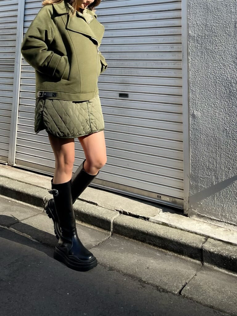 ベージュ系のブルゾン、ブラック系のニット/セーター、ブラック系のブーツを着用したレディースの冬コーディネートの7枚目の写真