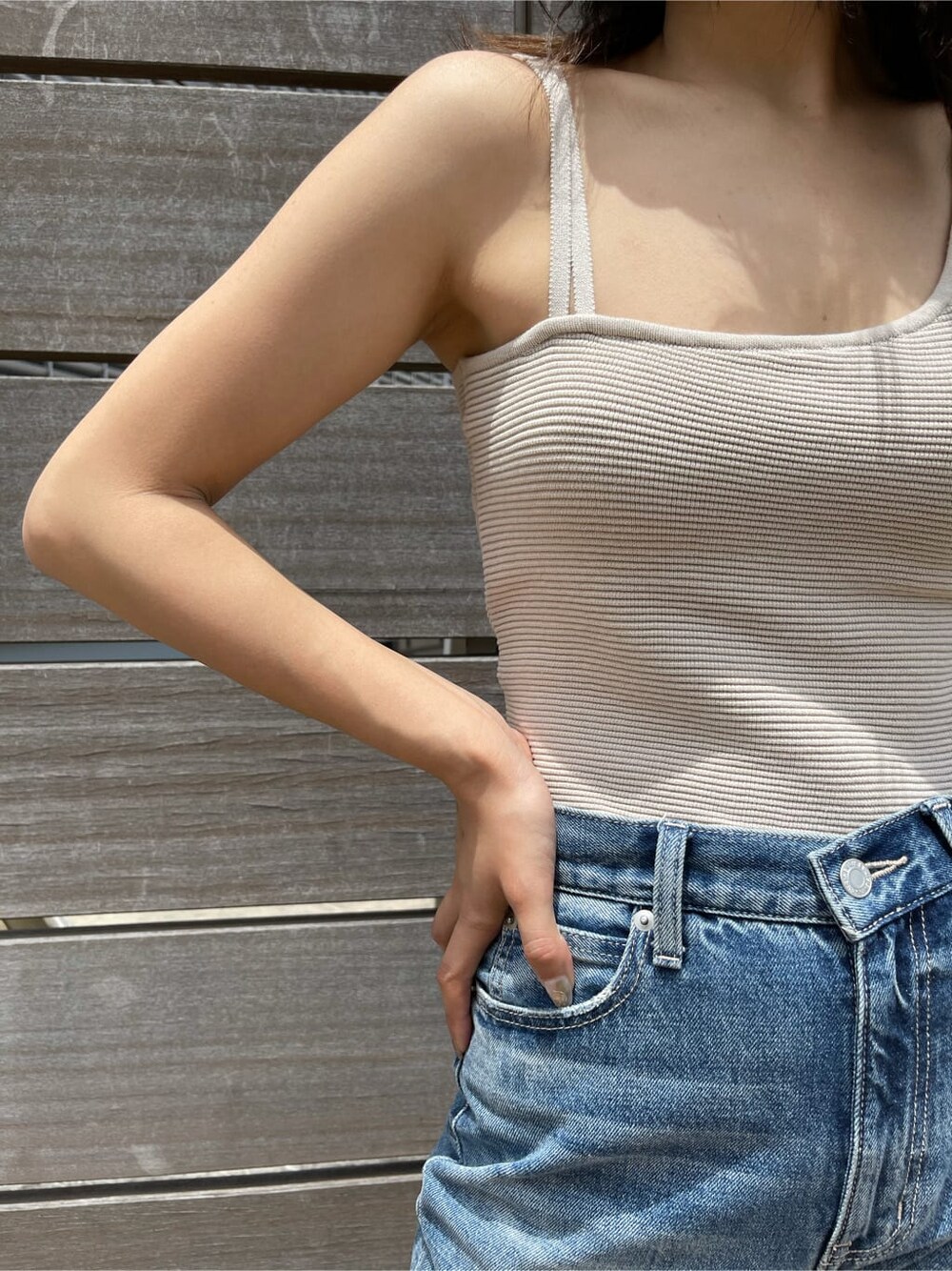 ブルー系のデニムパンツ、ブラウン系のサンダル、ホワイト系のTシャツ/カットソーを着用したレディースの夏コーディネートの5枚目の写真