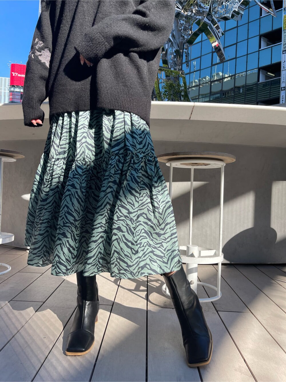 ブラック系のブーツ、グリーン系のワンピース、ブラック系のニット/セーターを着用したレディースの冬コーディネートの6枚目の写真