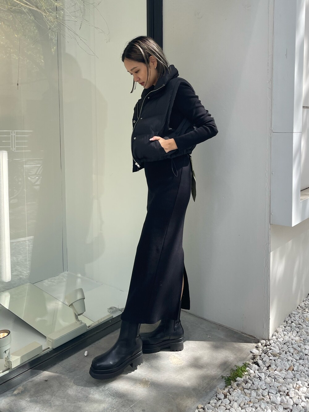 ブラック系のワンピース、ブラック系のブーツ、ブラック系のショルダーバッグを着用したレディースの秋コーディネートの2枚目の写真