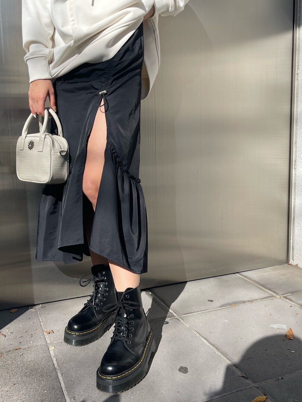 ホワイト系のパーカー、ホワイト系のショルダーバッグ、ブラック系のブーツを着用したレディースの冬コーディネートの5枚目の写真