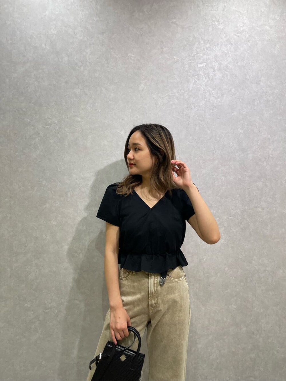 ブラック系のシャツ/ブラウス、ベージュ系のデニムパンツ、ホワイト系のサンダルを着用したレディースの春コーディネートの7枚目の写真