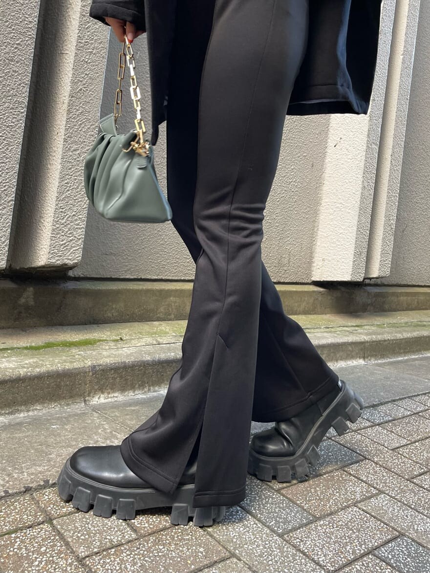 ブラック系のブーツ、ブラック系のその他アウター、グリーン系のショルダーバッグを着用したレディースの秋コーディネートの9枚目の写真