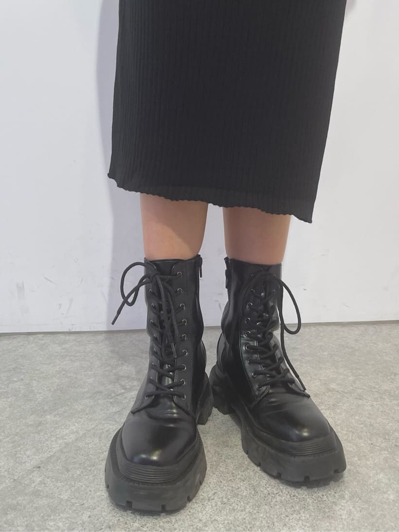 ブラック系のブーツ、ブラック系のワンピース、シルバー系のバングル/リストバンドを着用したレディースの秋コーディネートの4枚目の写真