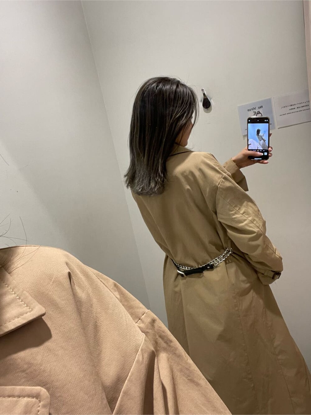 ブラック系のパンプス、ベージュ系のトレンチコート、ブルー系のデニムパンツを着用したレディースの冬コーディネートの5枚目の写真