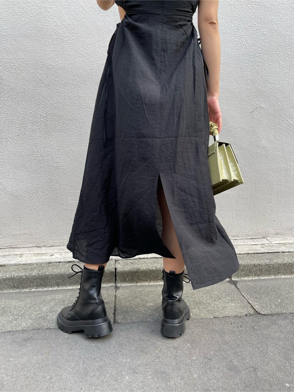 ブラック系のブーツ、グリーン系のショルダーバッグ、ブラック系のワンピースを着用したレディースの春コーディネートの5枚目の写真