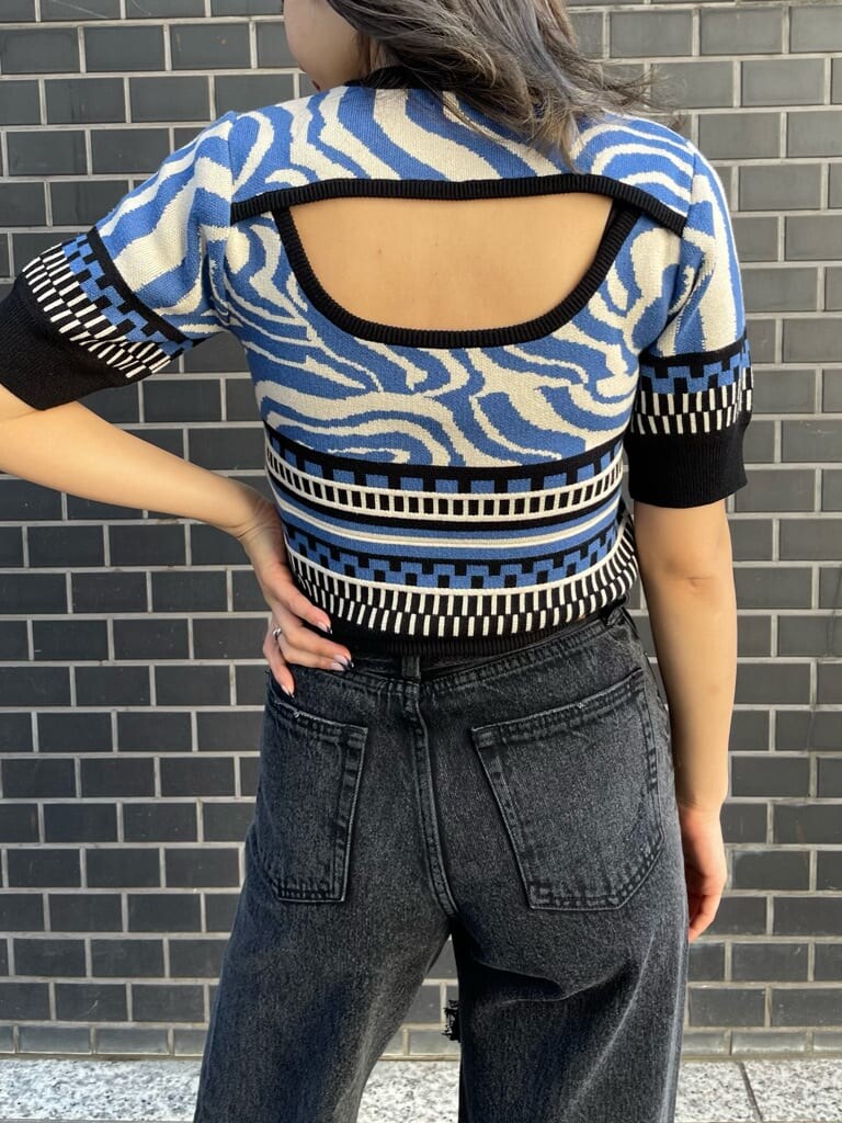 ブラック系のデニムパンツ、ブルー系のニット/セーター、ブラック系のブーツを着用したレディースの春コーディネートの6枚目の写真