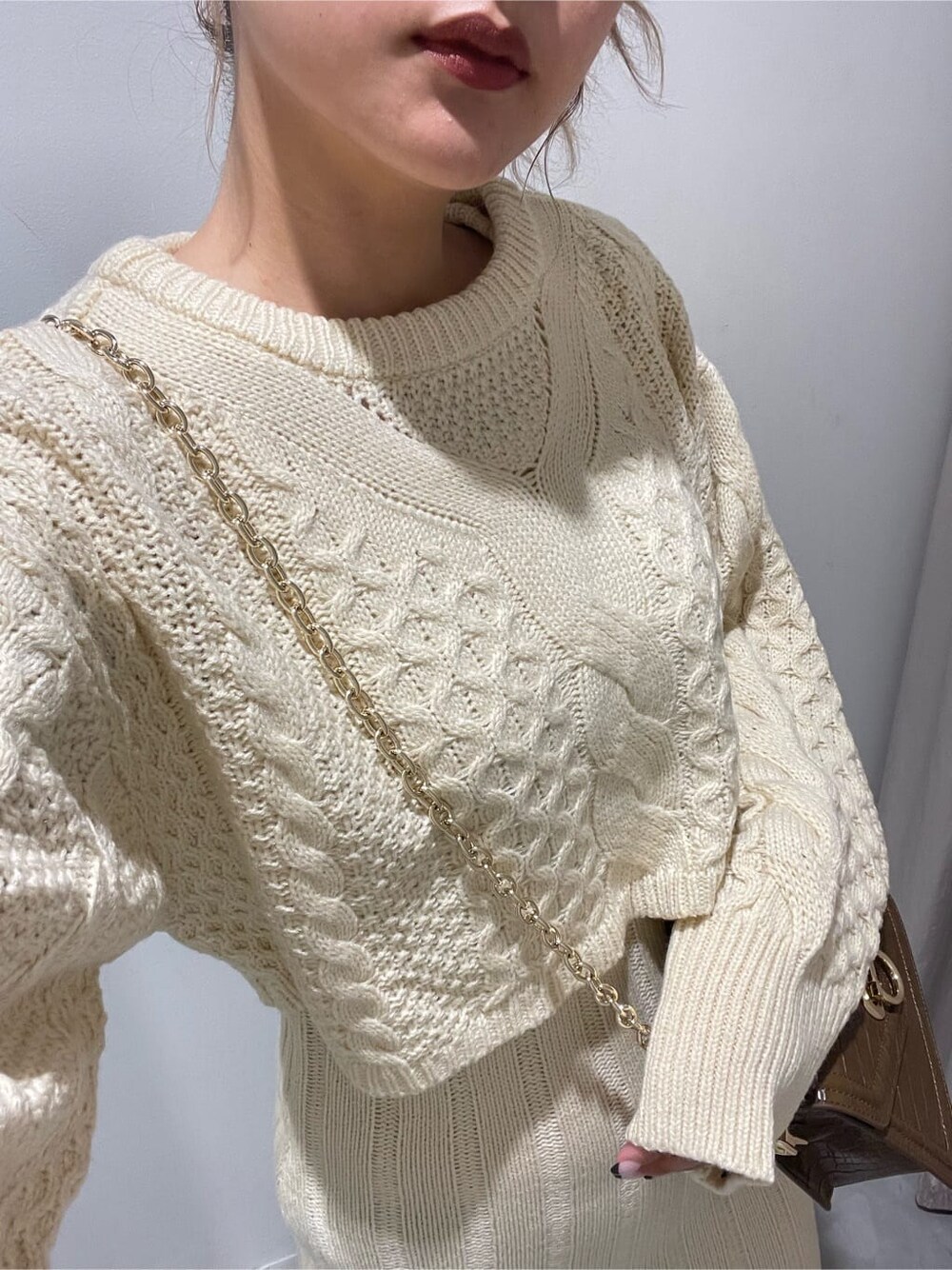 ブラック系のブーツ、ホワイト系のワンピース、ブラウン系のハンドバッグを着用したレディースの秋コーディネートの4枚目の写真