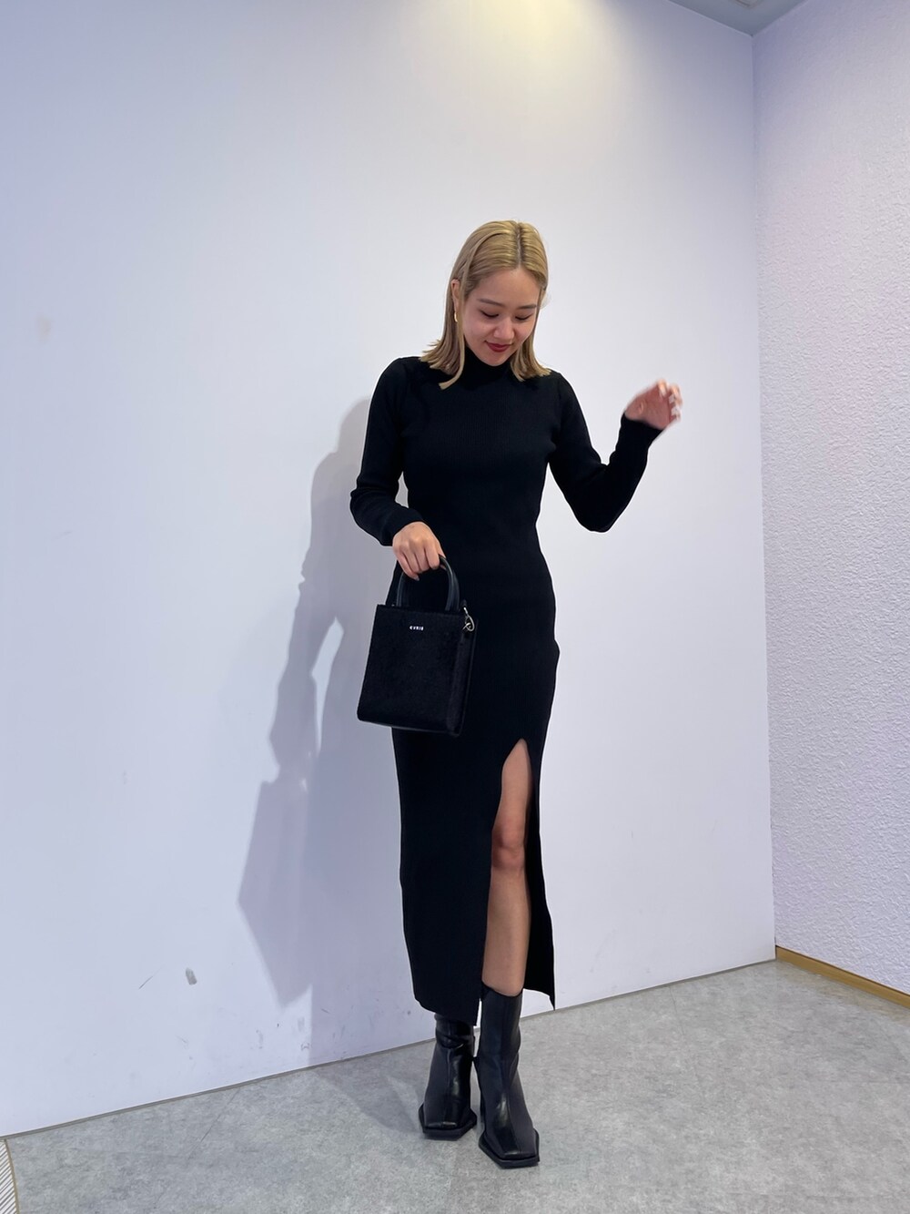 ブラック系のブーツ、ブラック系のショルダーバッグ、ブラック系のワンピースを着用したレディースの冬コーディネートの4枚目の写真