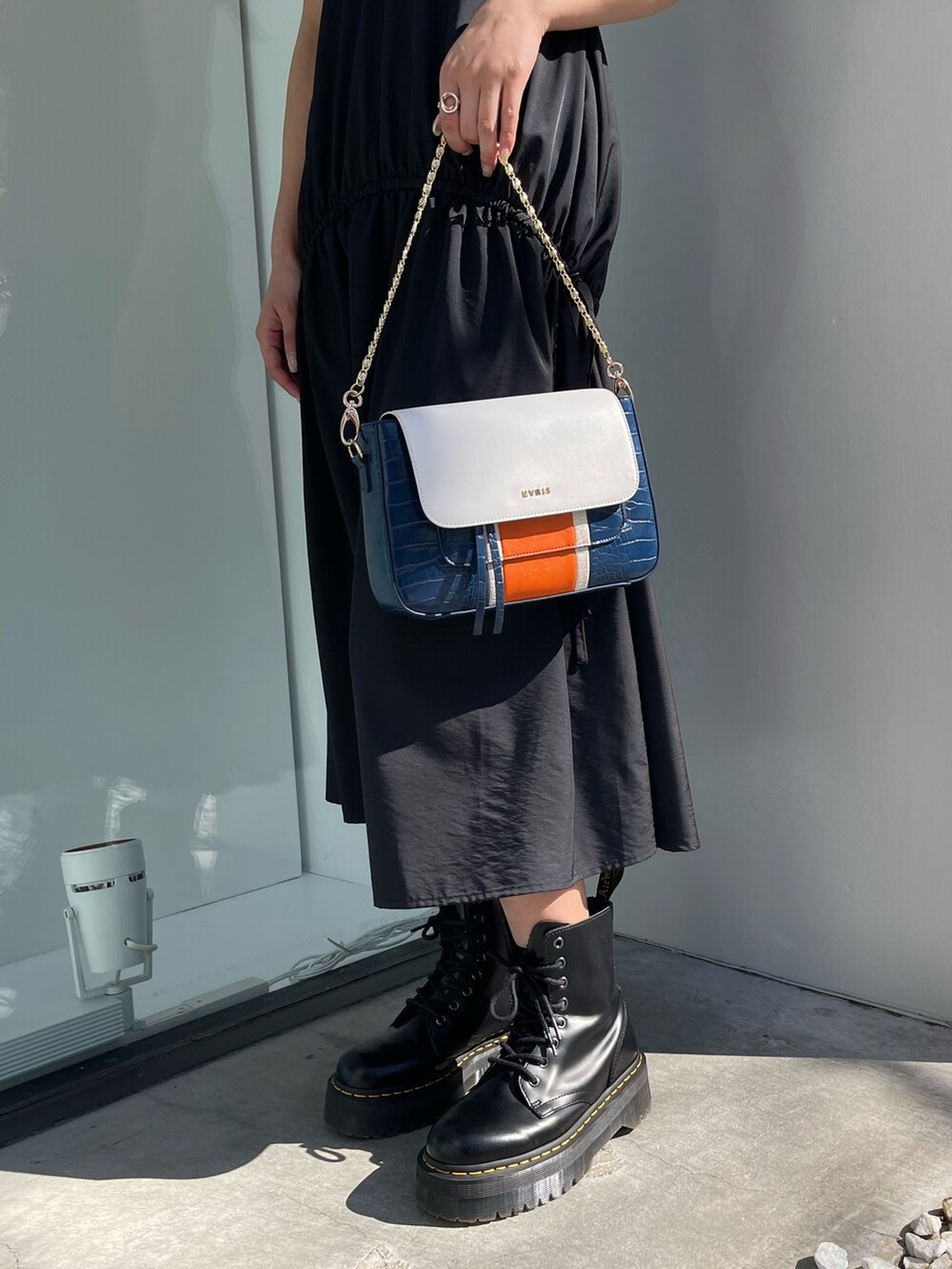 ブラック系のブーツ、ブルー系のショルダーバッグ、ブラック系のワンピースを着用したレディースの春コーディネートの8枚目の写真