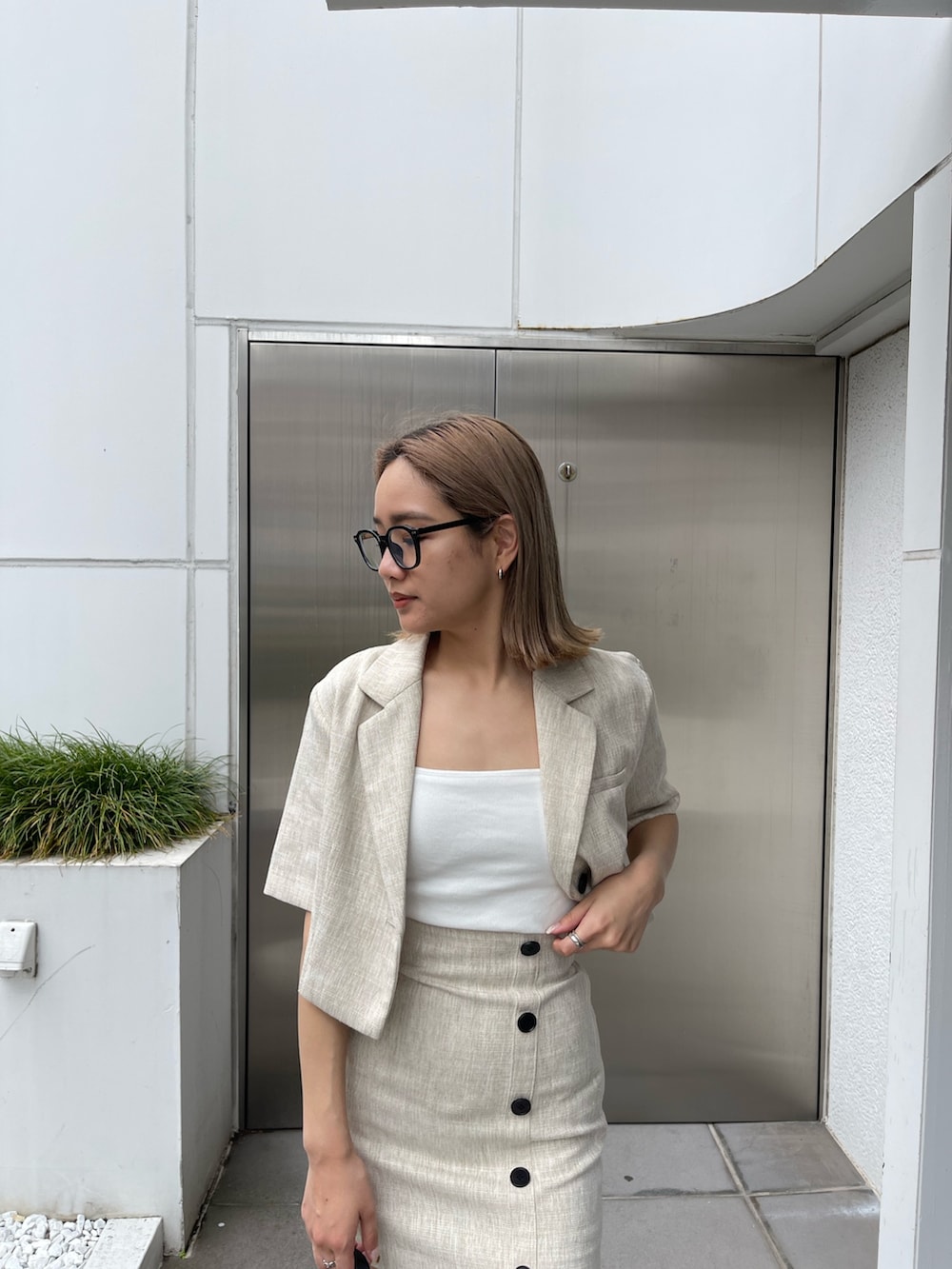 ブラック系のブーツ、ホワイト系のニット/セーター、ホワイト系のテーラードジャケットを着用したレディースの春コーディネートの7枚目の写真